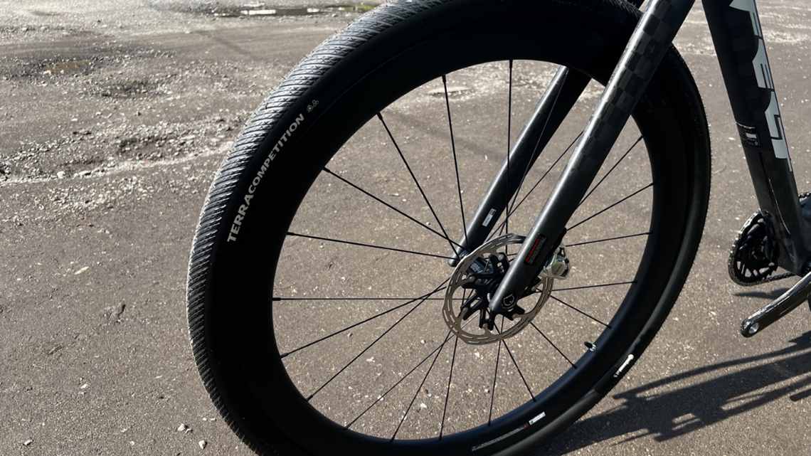 Widok z przodu na przednie koło roweru gravelowego. Opona Continental Terra Competition zamontowana jest na czarnej obręczy.